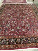 A Meshed burgundy ground carpet, signed by Akhondzadeh, 390 x 308cm