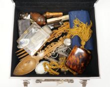 A metal case containing mixed collectibles including treen whistles, a cigarette case, three white