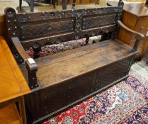 An 18th century style brass studded carved oak box seat settle, length 136cm, depth 40cm, height
