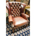 A George III style button back burgundy leather wing armchair, width 83cm, depth 66cm, height 82cm