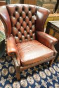 A George III style button back burgundy leather wing armchair, width 83cm, depth 66cm, height 82cm