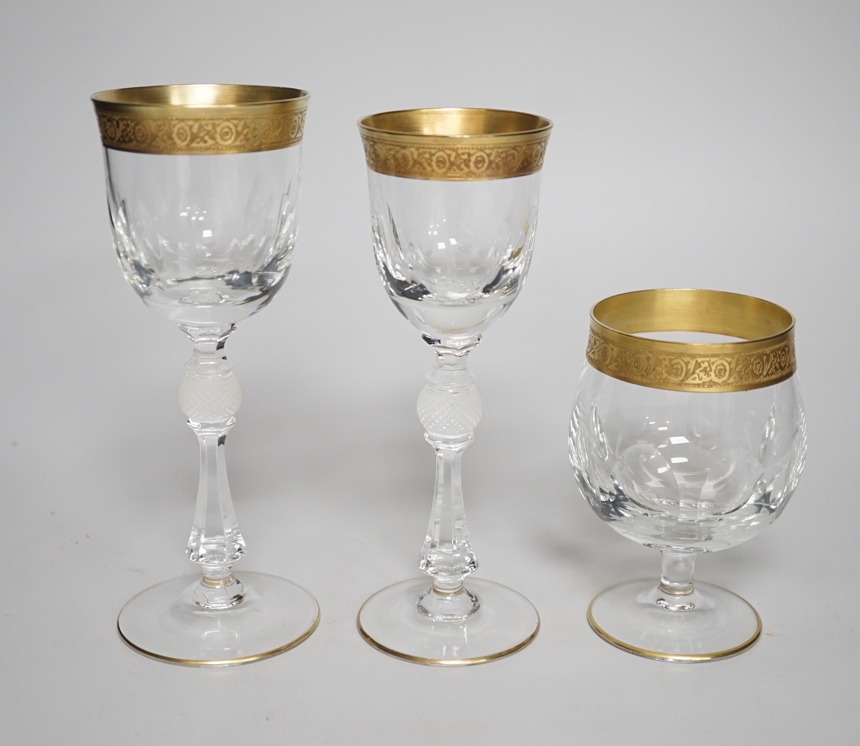 A Harrods retailed parcel gilt and cut and moulded suite of drinking glasses, two decanters and