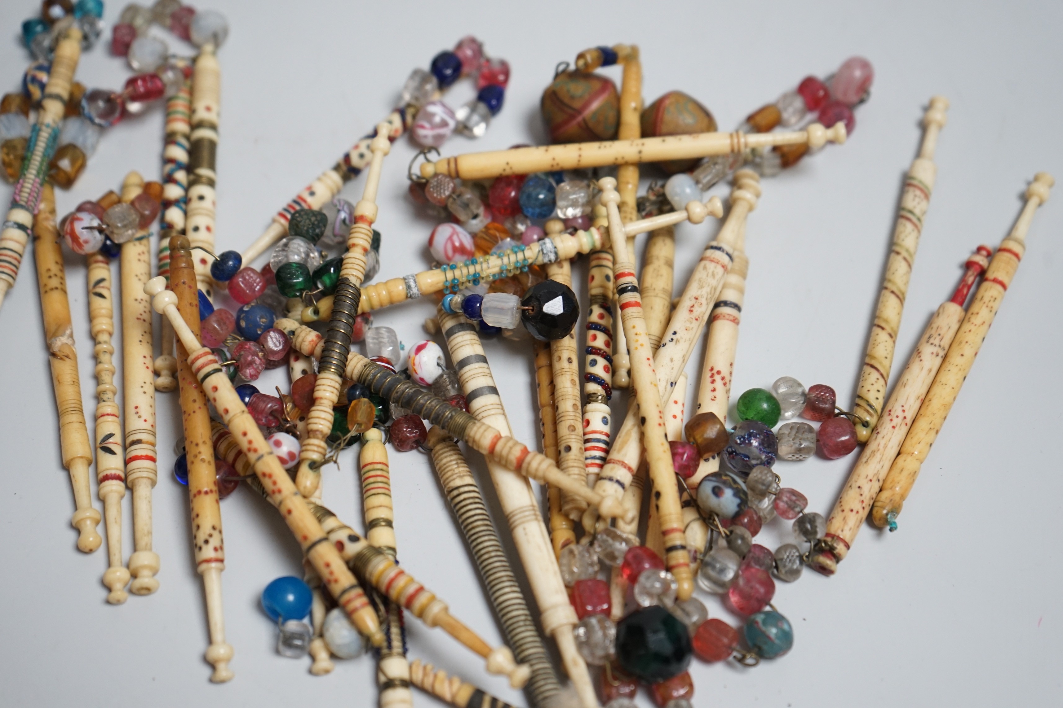 Twenty 19th century ornately decorated lace bobbins with glass bead tops and eleven carved bobbins - Image 4 of 5