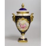 A Coalport urn and cover decorated with a floral reserve on a blue ground, 24cm