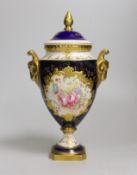 A Coalport urn and cover decorated with a floral reserve on a blue ground, 24cm