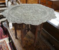 An Indian circular pierced brass tray top table, on carved folding stand, diameter 83cm, height