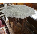 An Indian circular pierced brass tray top table, on carved folding stand, diameter 83cm, height