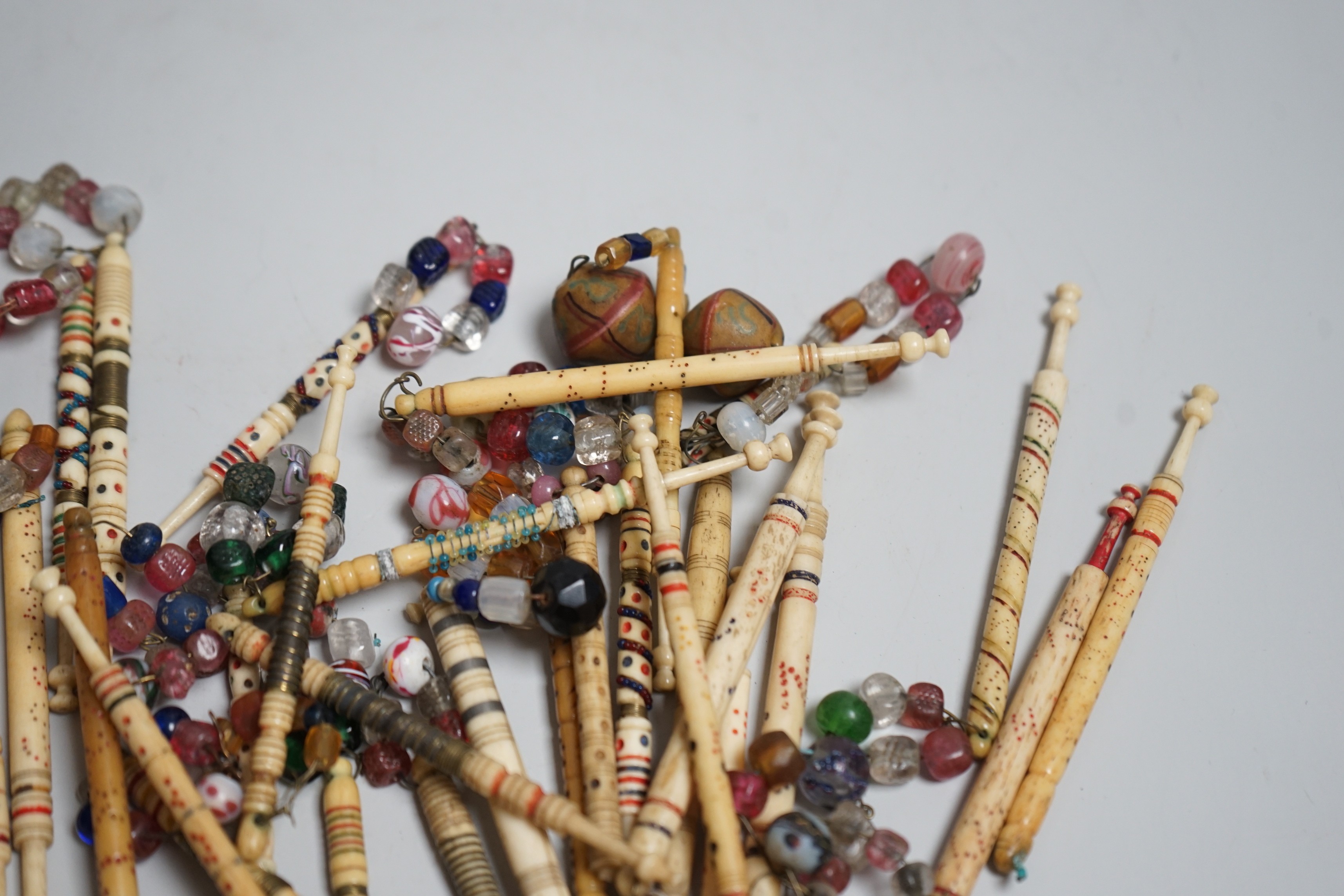 Twenty 19th century ornately decorated lace bobbins with glass bead tops and eleven carved bobbins - Image 3 of 5