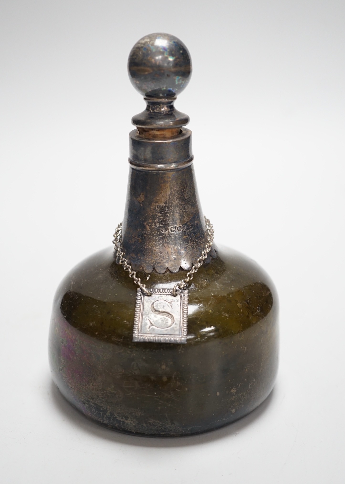 An 18th century green glass onion-shape bottle, with later silver mount, London, 1899, together with
