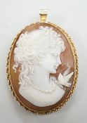A modern 9ct gold mounted oval cameo shell pendant brooch, carved with a bird and bust of a lady