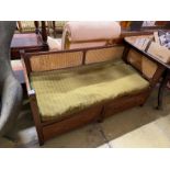 A provincial rustic oak bergère caned two drawer low bench seat, length 136cm, depth 61cm, height