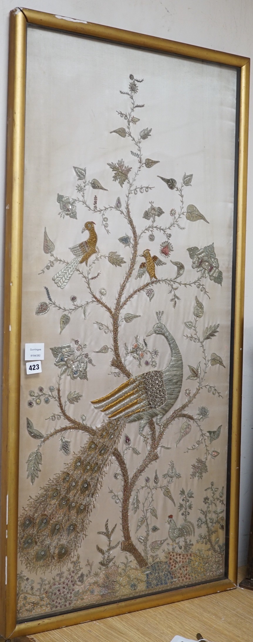 A framed silk, multi coloured metal thread embroidered Indian panel: a peacock seated amongst birds,