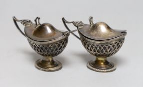 A pair of Edwardian pieced silver pedestal boat shaped mustard pots, E.S. Barnsley & Co, Birmingham,