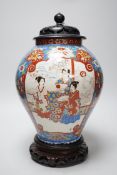 A large Japanese vase with carved wooden cover and base, 38cms high