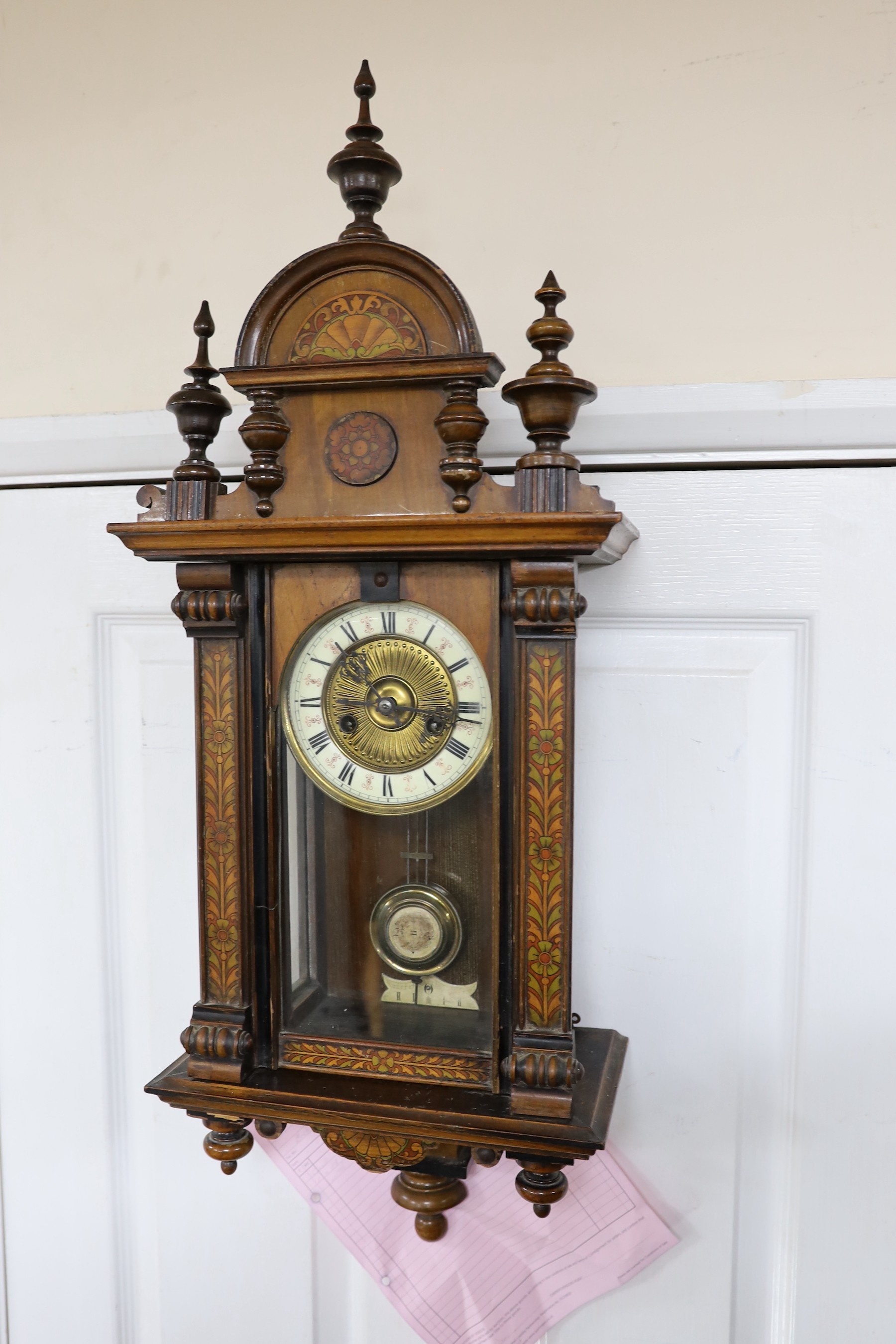 A small 19th century German wall clock with pendulum, 80cm long