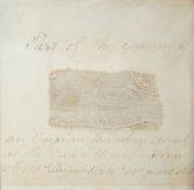 A small 19th century framed textile fragment, mounted with handwritten script; “part of the covering