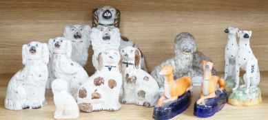 A mixed collection of mostly Staffordshire pottery models of recumbent dogs, hounds, etc. to include