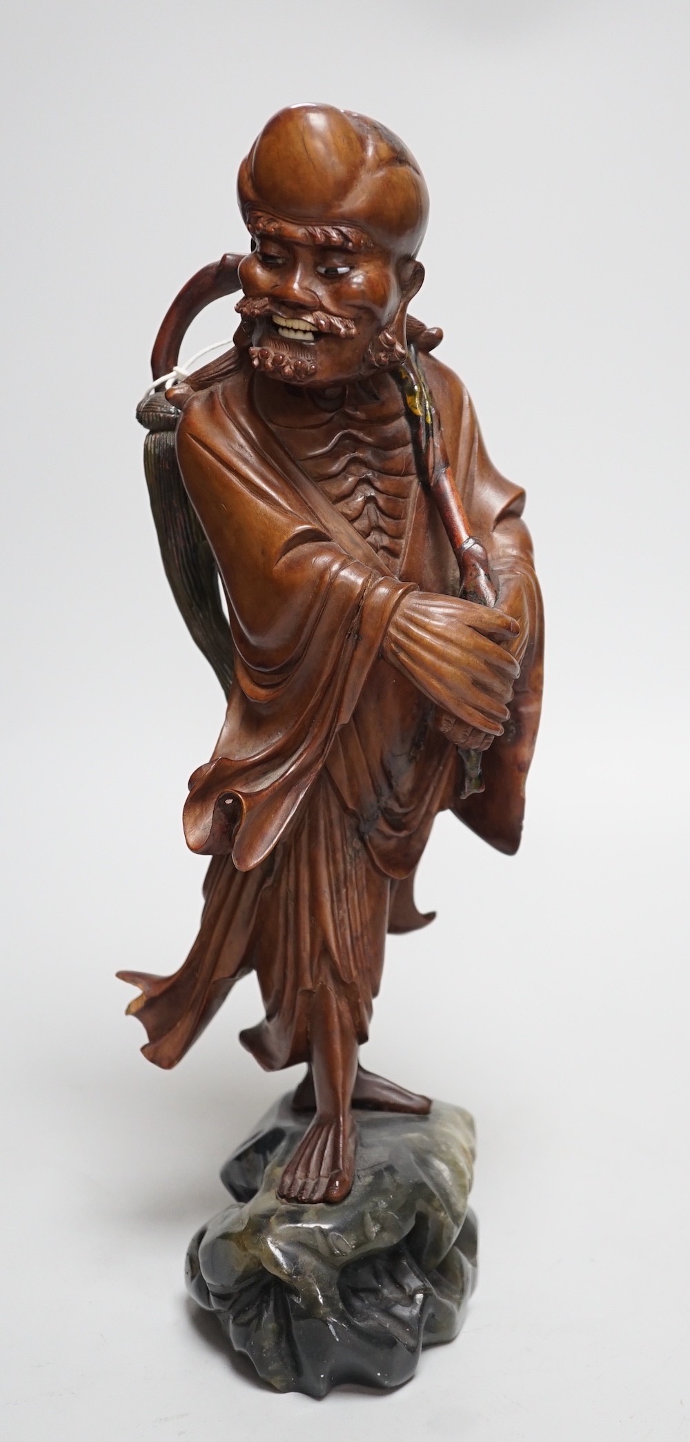 An early 20th century Chinese root carving of an immortal, on soapstone base, 36cm tall