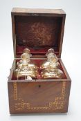 A George III inlaid mahogany decanter set with four gilt decorated decanters and two T.Goode & Co.