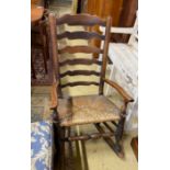 A 19th century Lancashire rush-seated ladder back rocking chair, width 54cm, depth 38cm, height