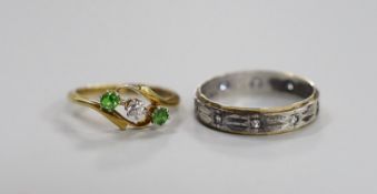 An 18ct and pt, diamond and green garnet set three stone crossover ring, size I/J, gross 2.5 grams