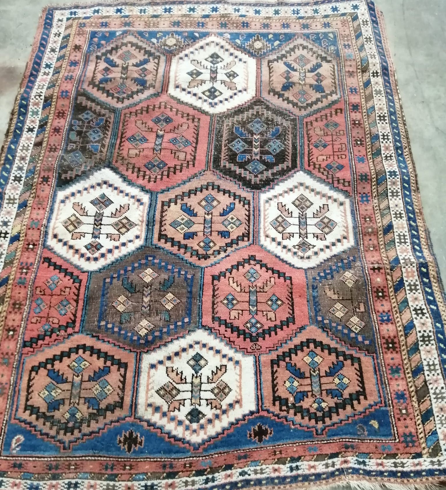 An early 20th century Caucasian blue ground rug woven rows of hexagonal medallions,162 x 124cm