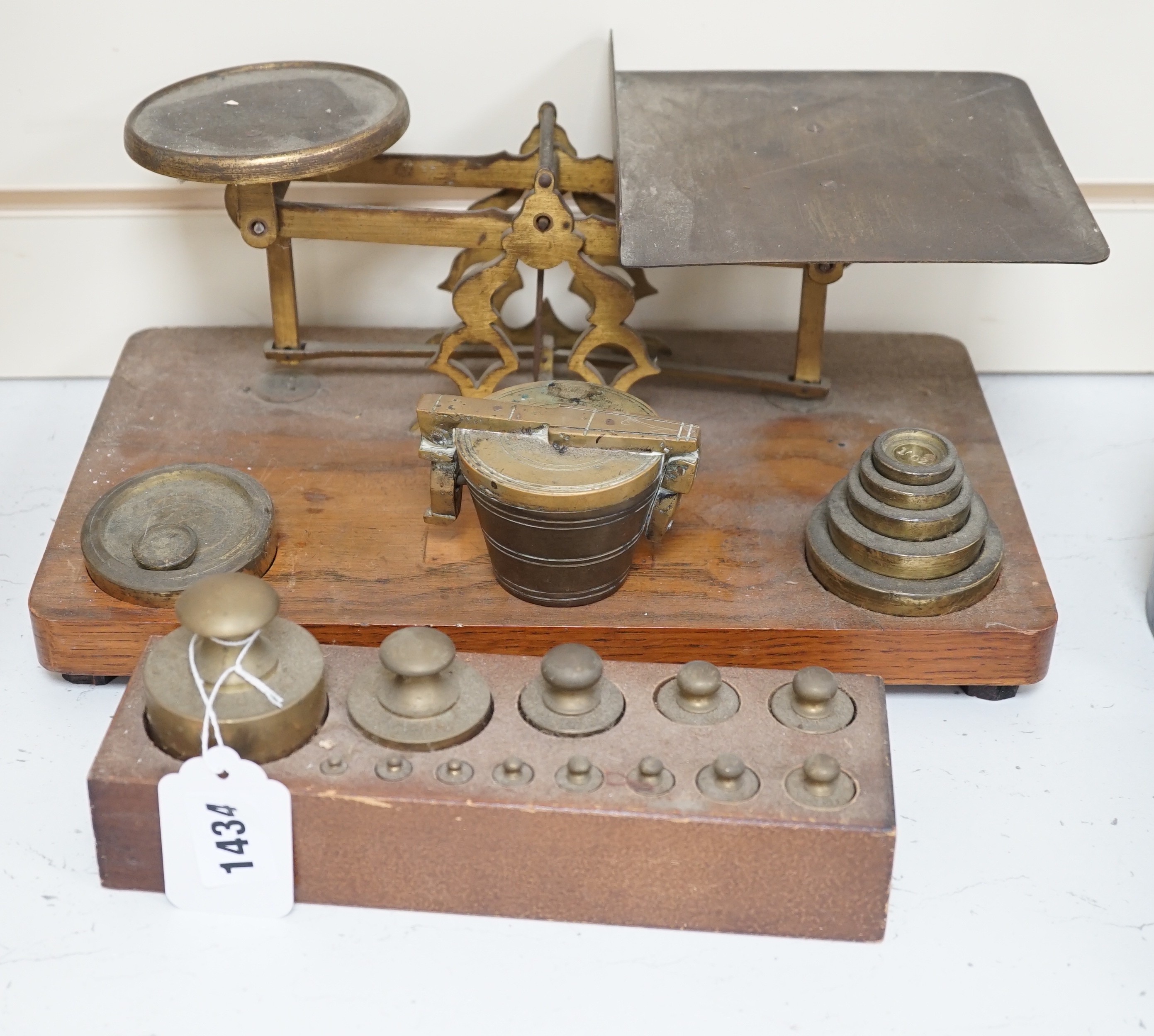 ° ° A set of brass postal scales and weights, a separate set of weights and another, set in wooden