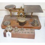 ° ° A set of brass postal scales and weights, a separate set of weights and another, set in wooden