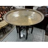 A Benares engraved brass circular tray top table on folding stand, diameter 67cm, height 59cm