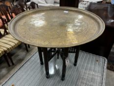 A Benares engraved brass circular tray top table on folding stand, diameter 67cm, height 59cm