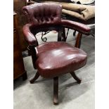 An early 20th century burgundy leather tub framed swivel desk chair, width 61cm, depth 50cm,