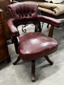 An early 20th century burgundy leather tub framed swivel desk chair, width 61cm, depth 50cm,