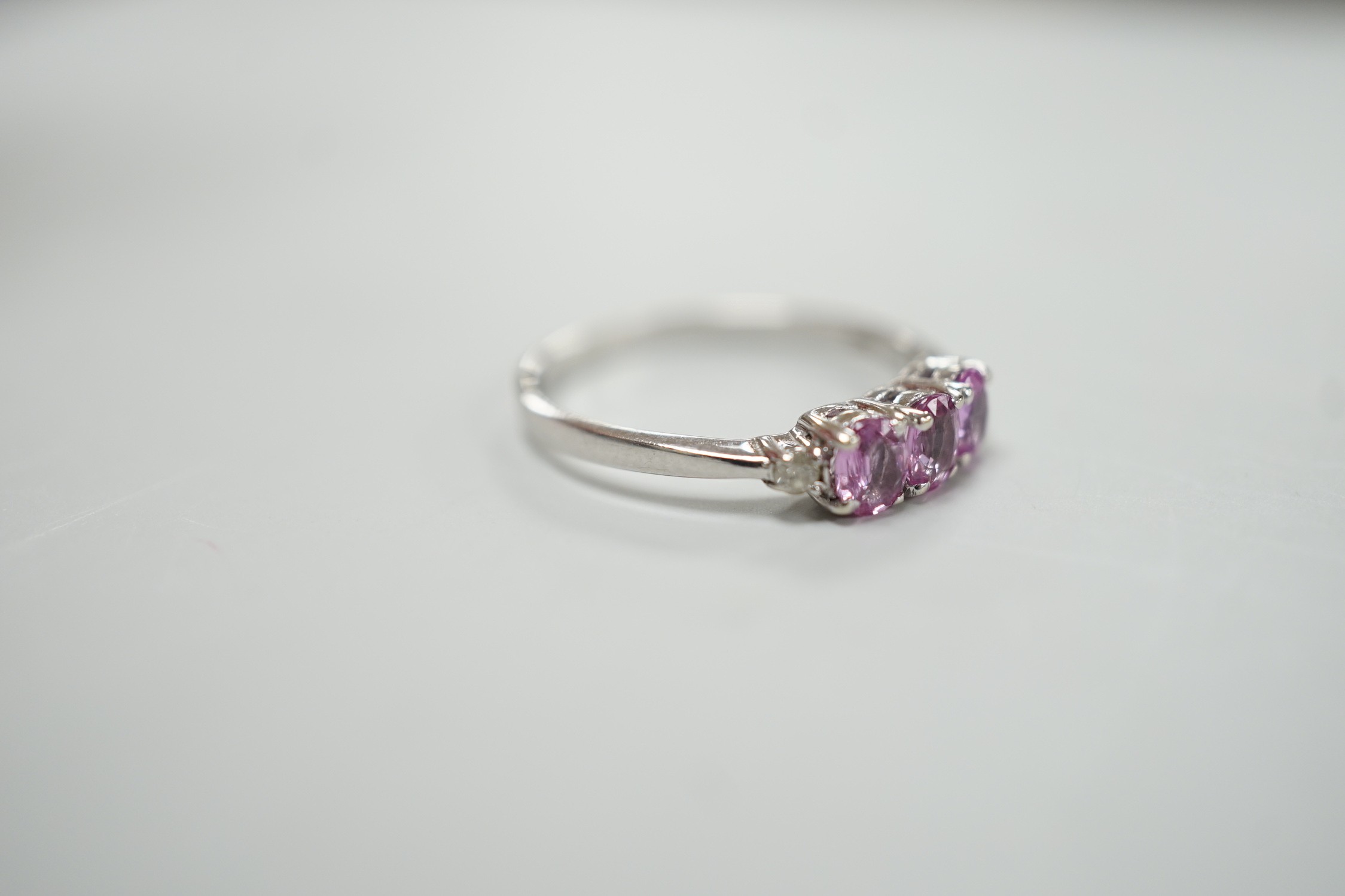 A modern 14ct white gold, three stone pink sapphire and two stone diamond chip set ring, size L, - Image 3 of 4