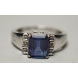 A modern 18k, single stone emerald cut tanzanite and six stone diamond cluster set ring, size O,