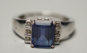 A modern 18k, single stone emerald cut tanzanite and six stone diamond cluster set ring, size O,