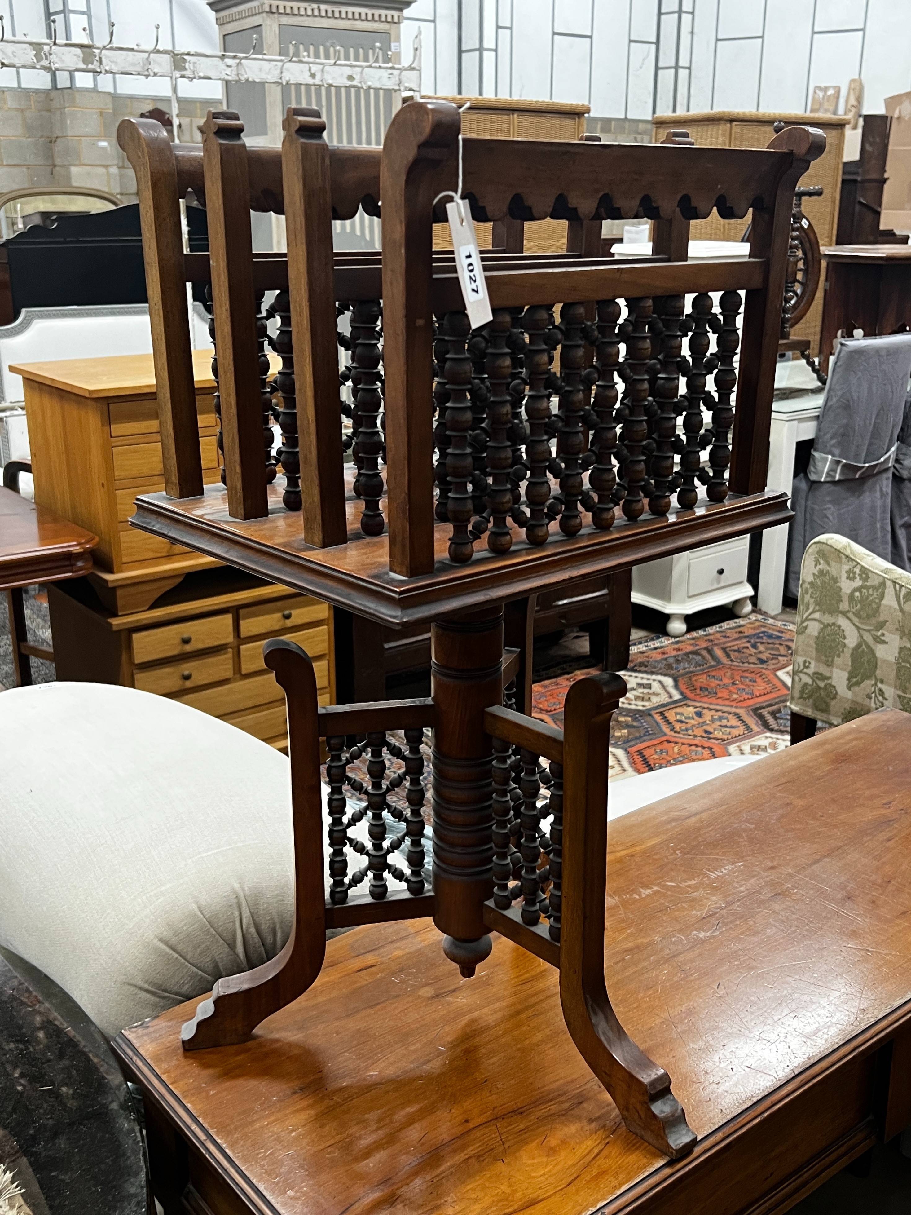 An early 20th century Moorish style walnut three division revolving newspaper stand, width 42cm,