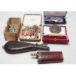 Two powder flasks and militaria including cap badges and miniature medals
