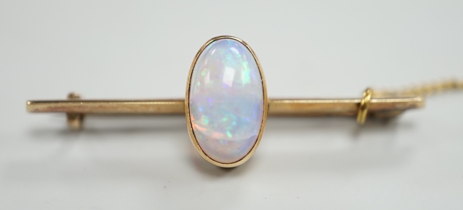 A yellow metal and single stone oval white opal set bar brooch, 39mm, gross weight 4.3 grams.