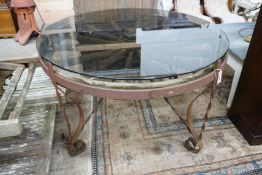 A wrought iron glass topped circular cartwheel garden table, diameter 124cm, height 72cm