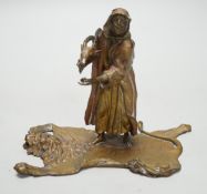 An Austrian cold painted bronze model of a Bedouin trader, depicted holding an Ibex head, standing