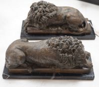 A pair of bronze recumbent lions on black marble bases 33cm