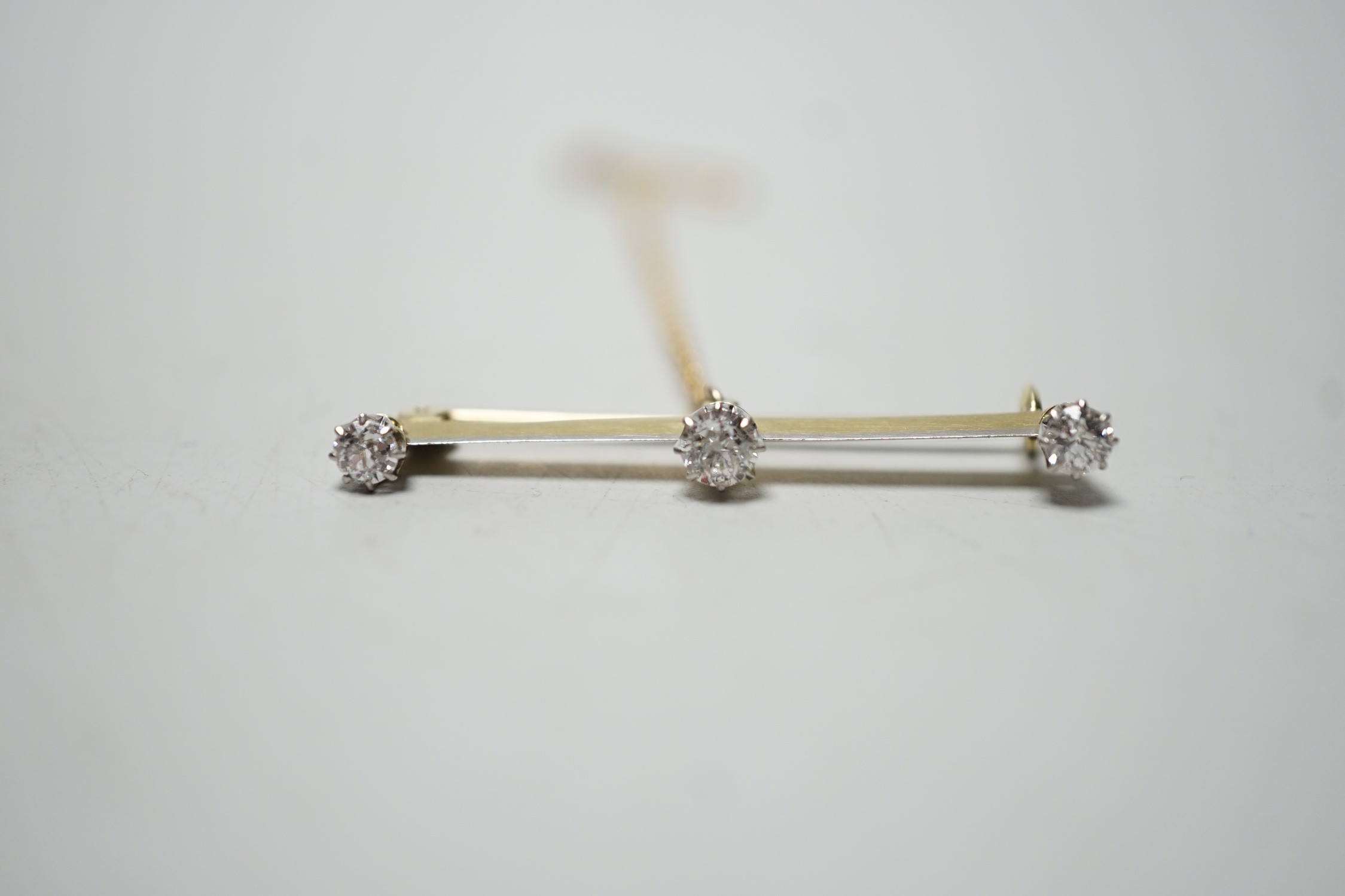 A yellow metal and three stone diamond set bar brooch, 36mm, gross weight 2.8 grams. - Image 2 of 5