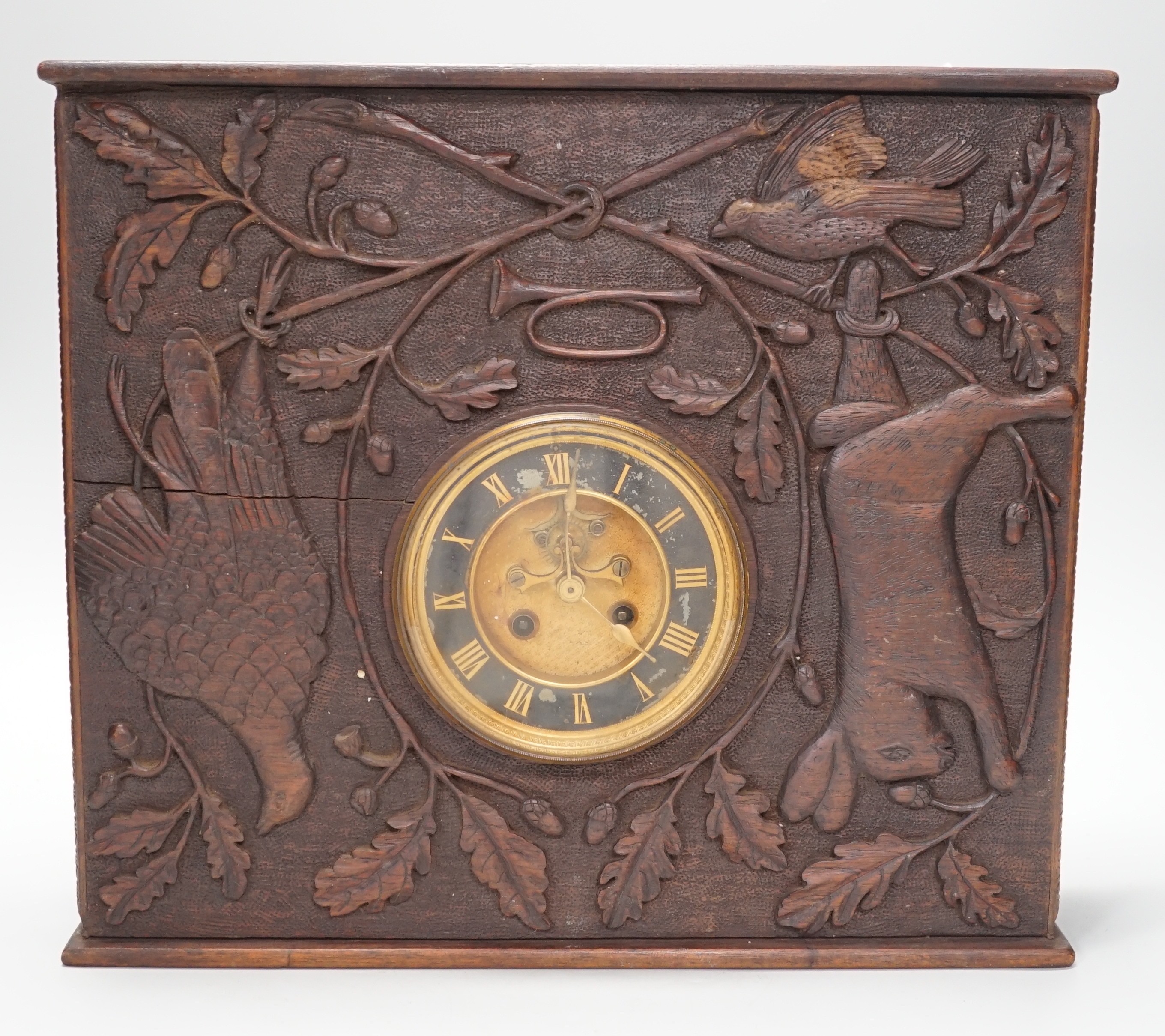 A late 19th century / early 20th century folk art carved oak cased clock, decorated with hanging