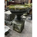 A reconstituted stone circular campana planter on square plinth, diameter 80cm, height 102cm