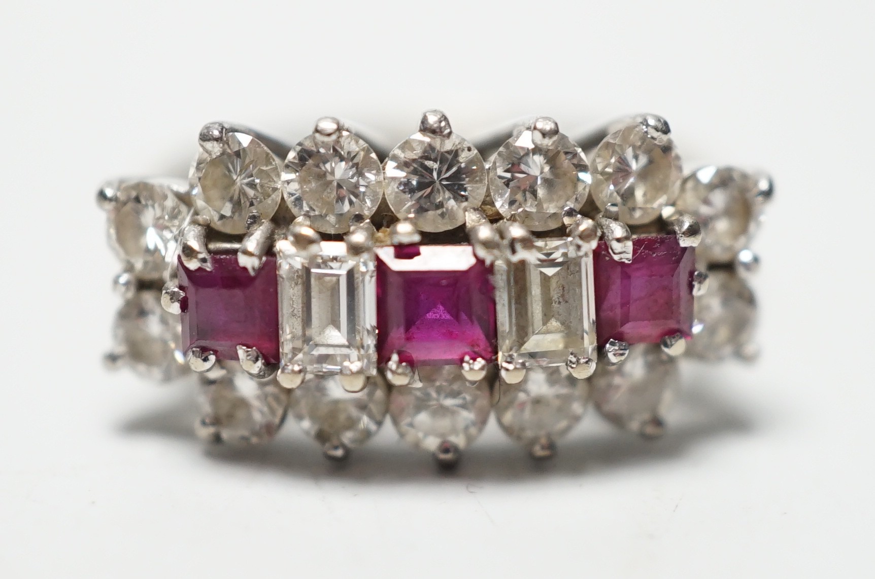 A modern 18ct white gold, square cut ruby and round and baguette cut diamond set cluster ring,