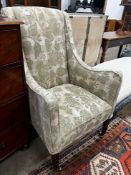 A 19th century wing armchair upholstered in patterned green floral fabric, width 68cm, depth 75cm,