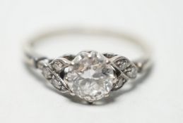 An 18ct white metal and single stone diamond ring, with diamond chip set shoulders, the stone