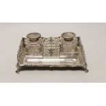 A George V pierced silver rectangular inkstand, with two mounted glass bottles and pen recess,