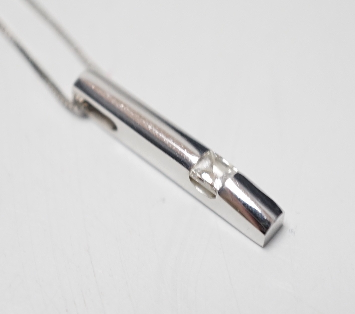 A modern 18ct white gold and solitaire diamond set pendant, 22mm, on an 18ct white gold fine link