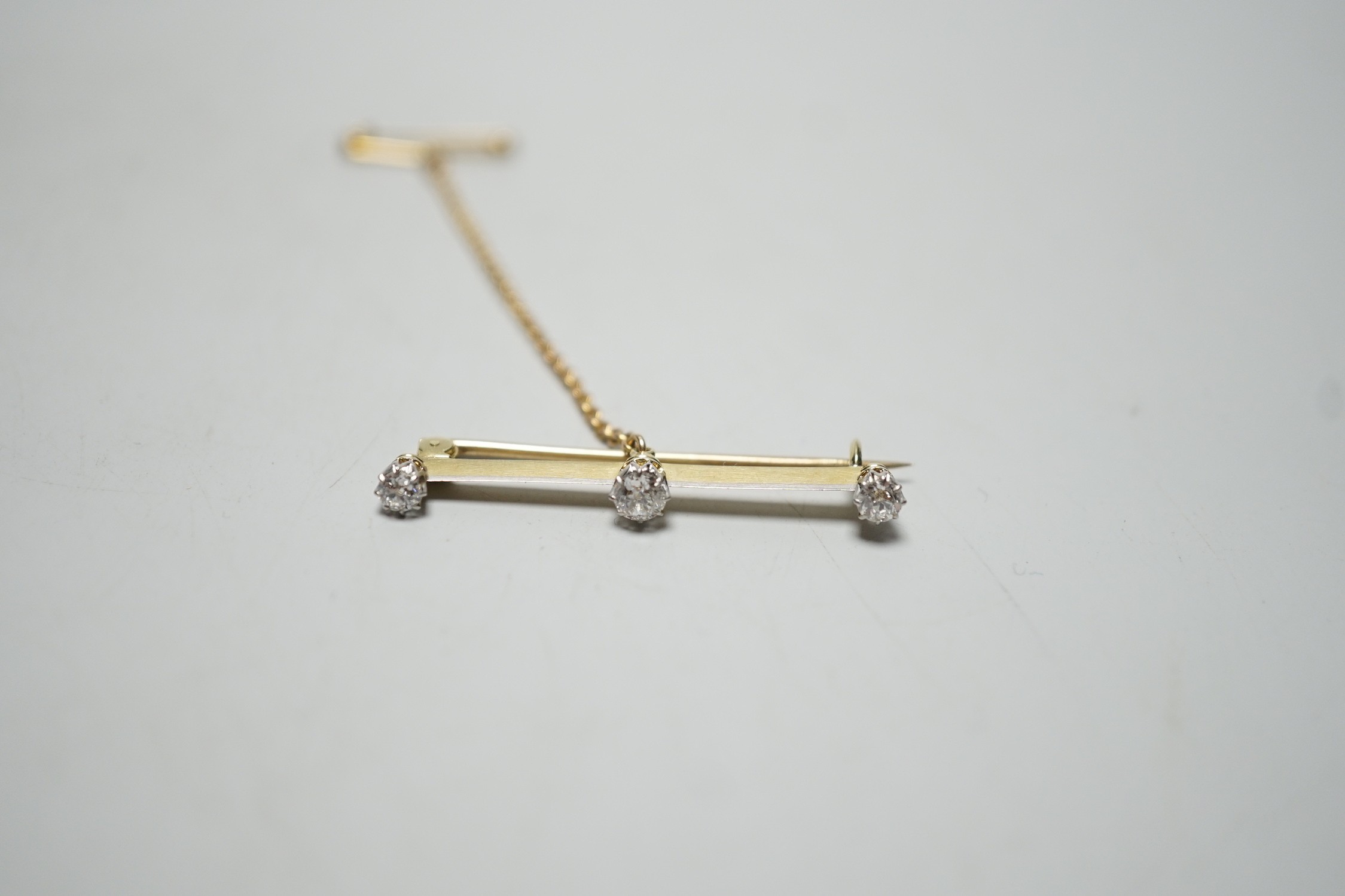 A yellow metal and three stone diamond set bar brooch, 36mm, gross weight 2.8 grams. - Image 5 of 5